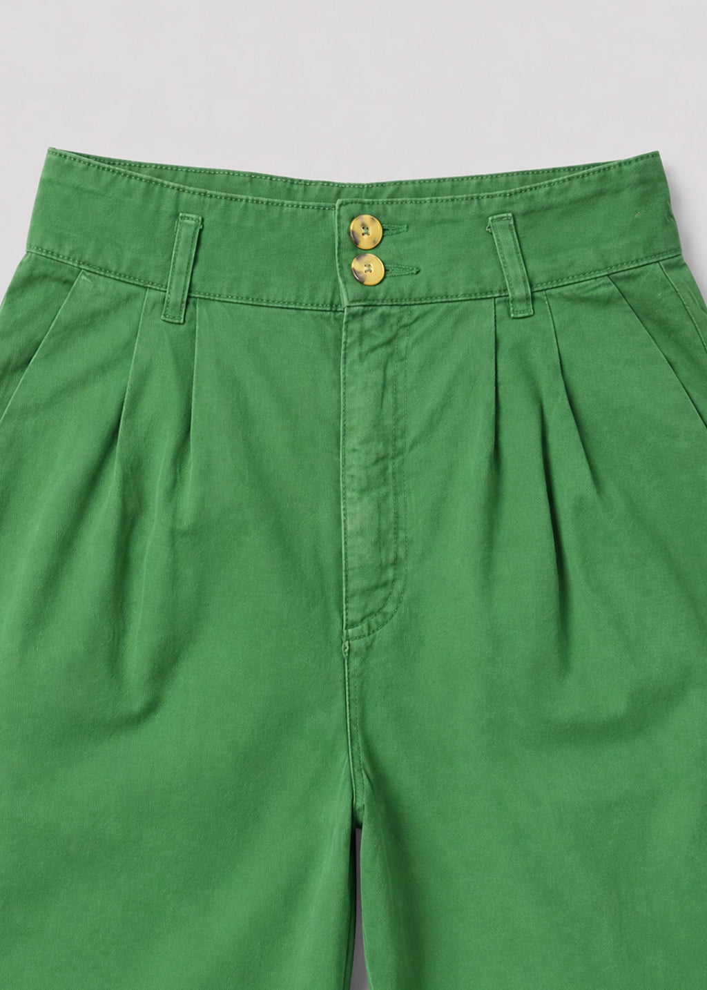 Green pleated trousers double-button waistband detail