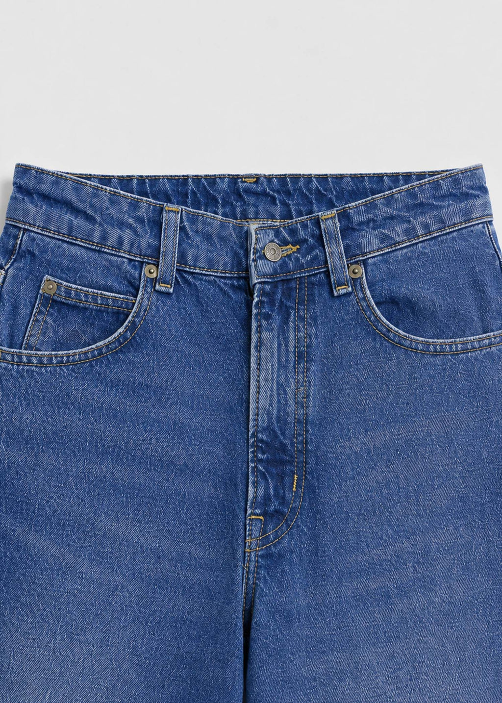 Medium-wash jeans waistband five-pocket and button detail