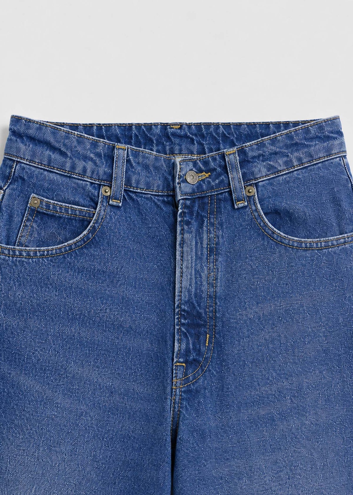 Medium-wash jeans waistband five-pocket and button detail