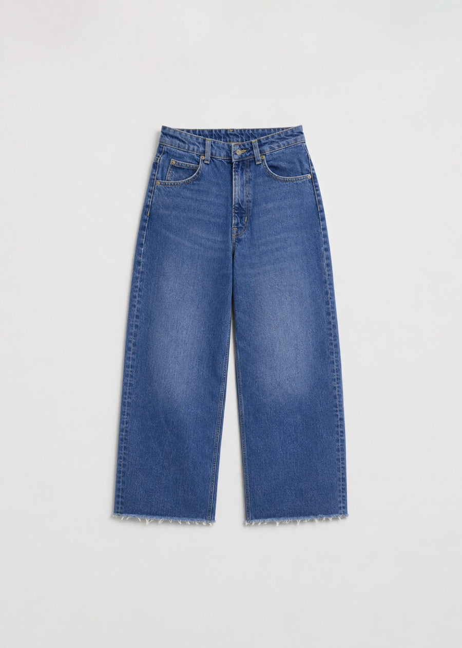 Medium-wash wide-leg jeans front view with raw frayed hem