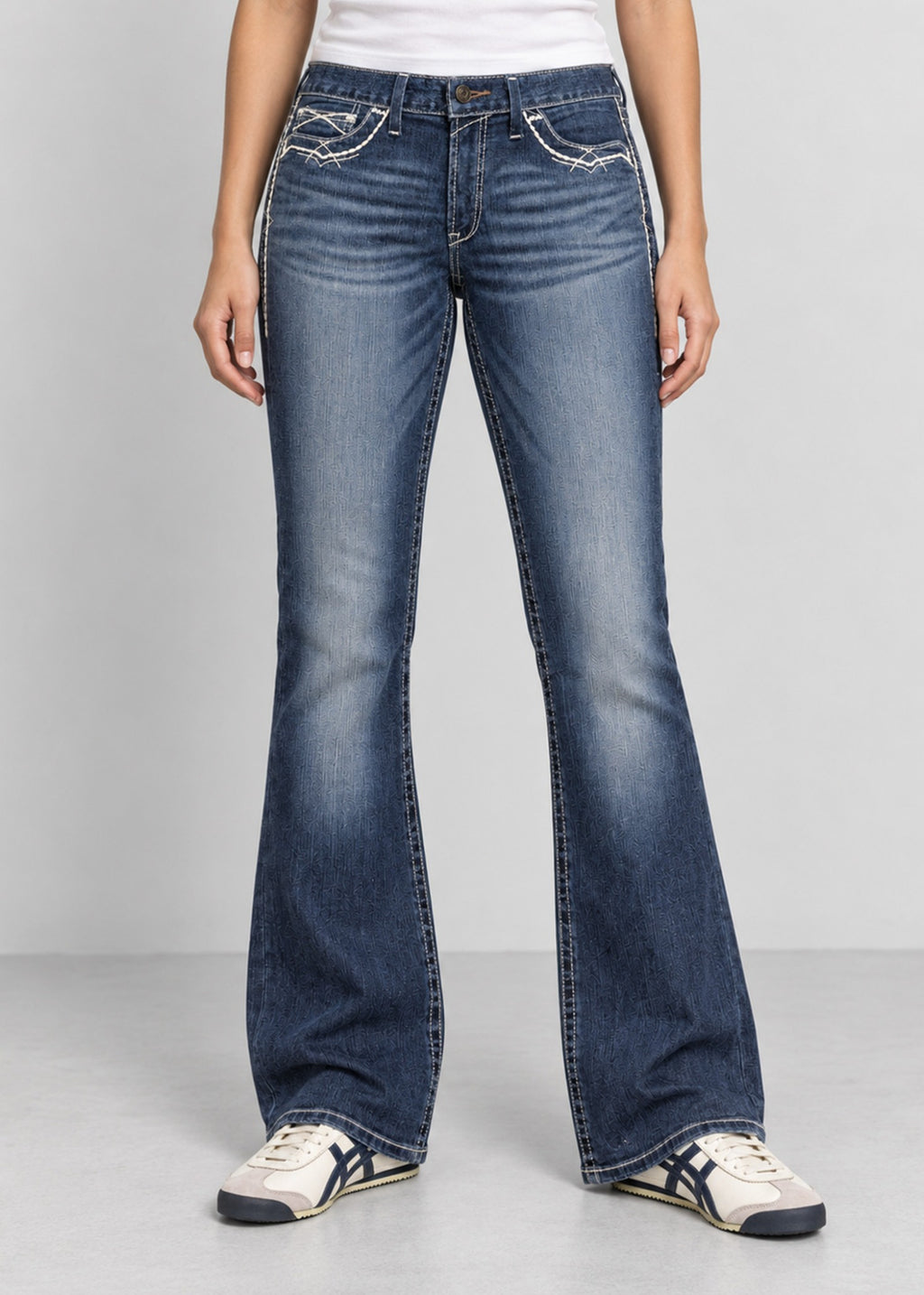 Unisex blue wash bootcut jeans on female model, front view