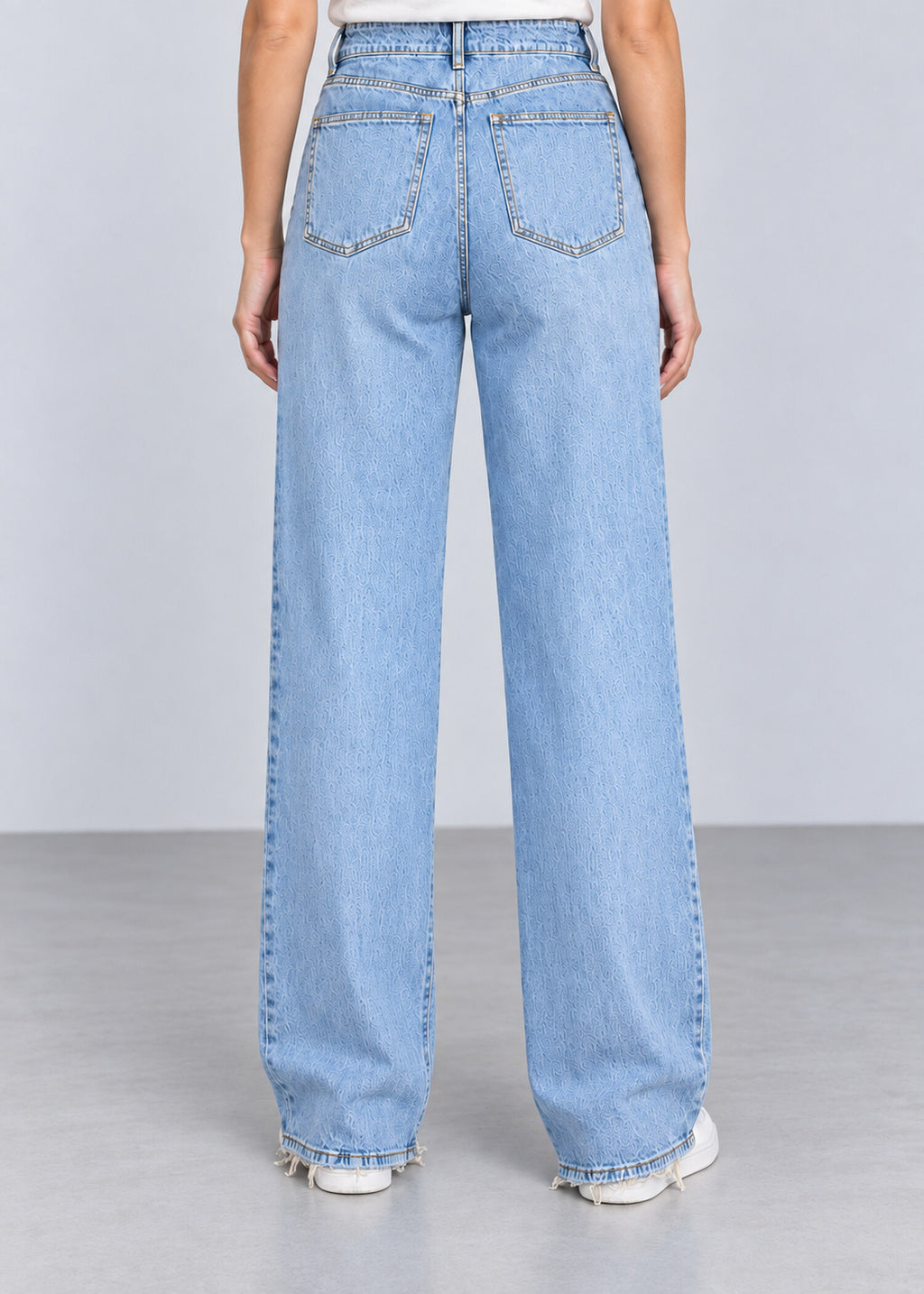 Light wash wide leg raw hem jeans on female model, back view