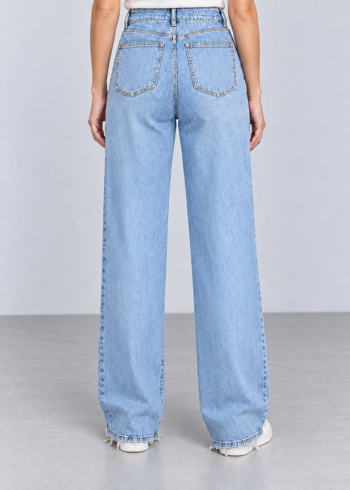 Light wash wide leg raw hem jeans on female model, back view