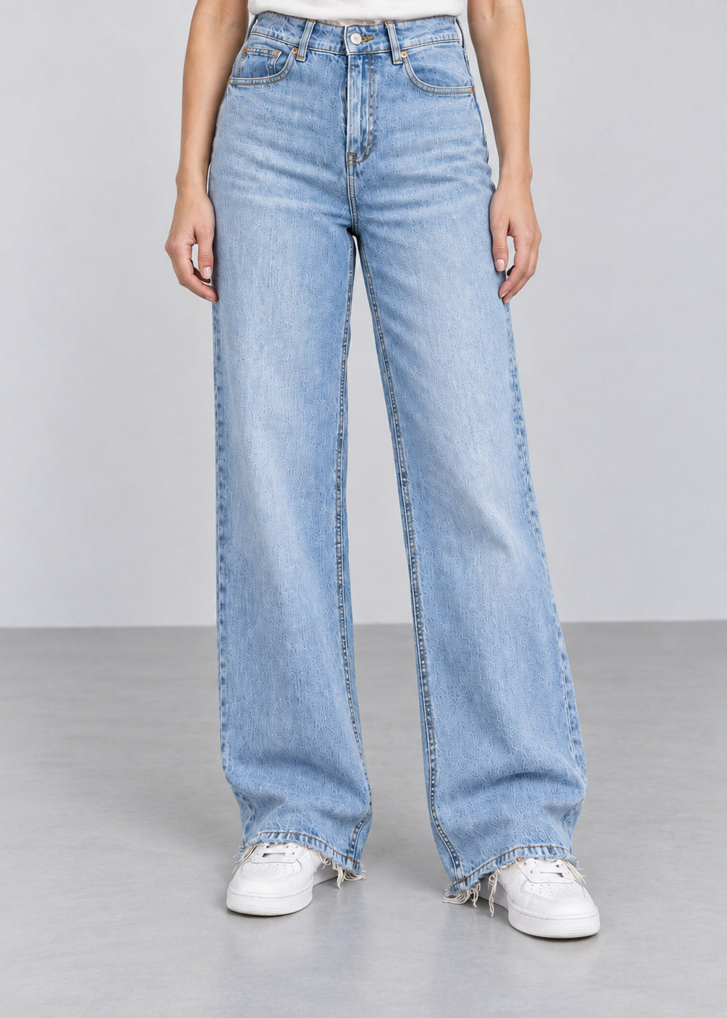 Light wash wide leg raw hem jeans on female model, front view