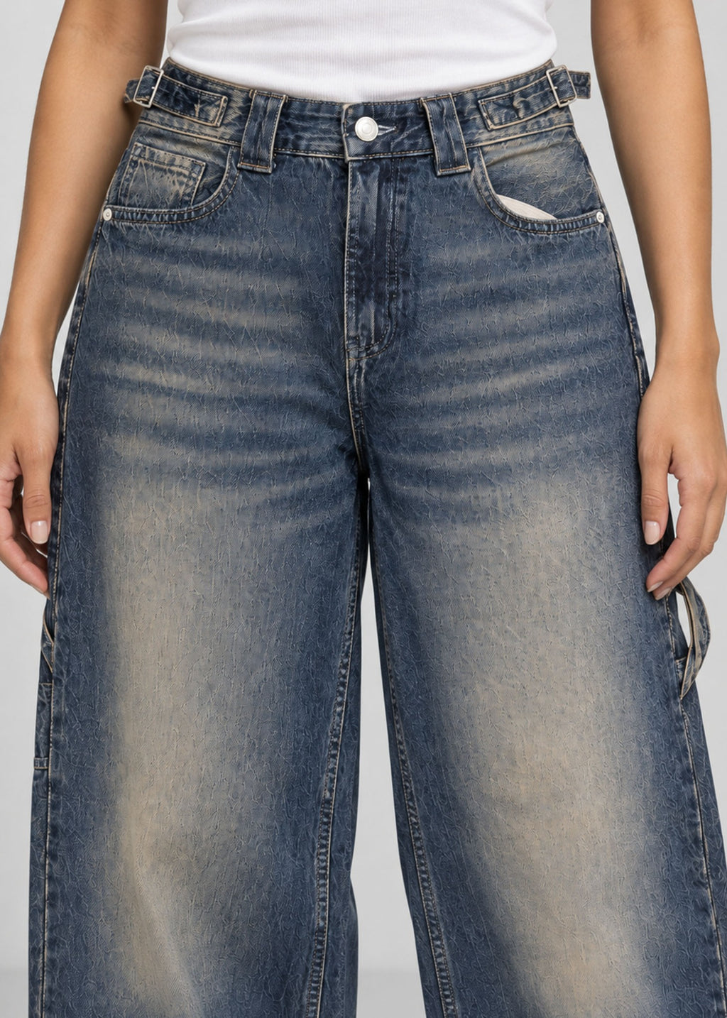 Medium blue balloon fit utility jeans button waist and whiskering close up