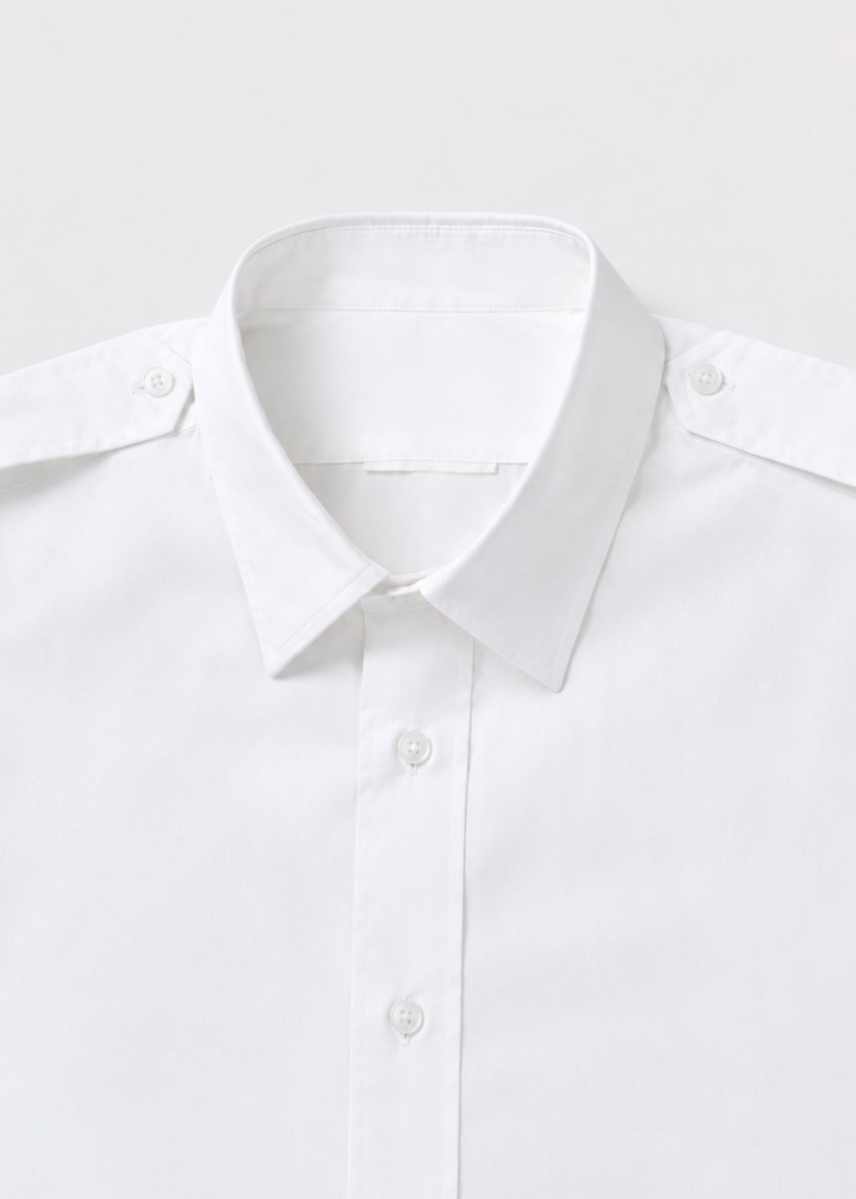 White epaulette shirt collar and shoulder-button close-up