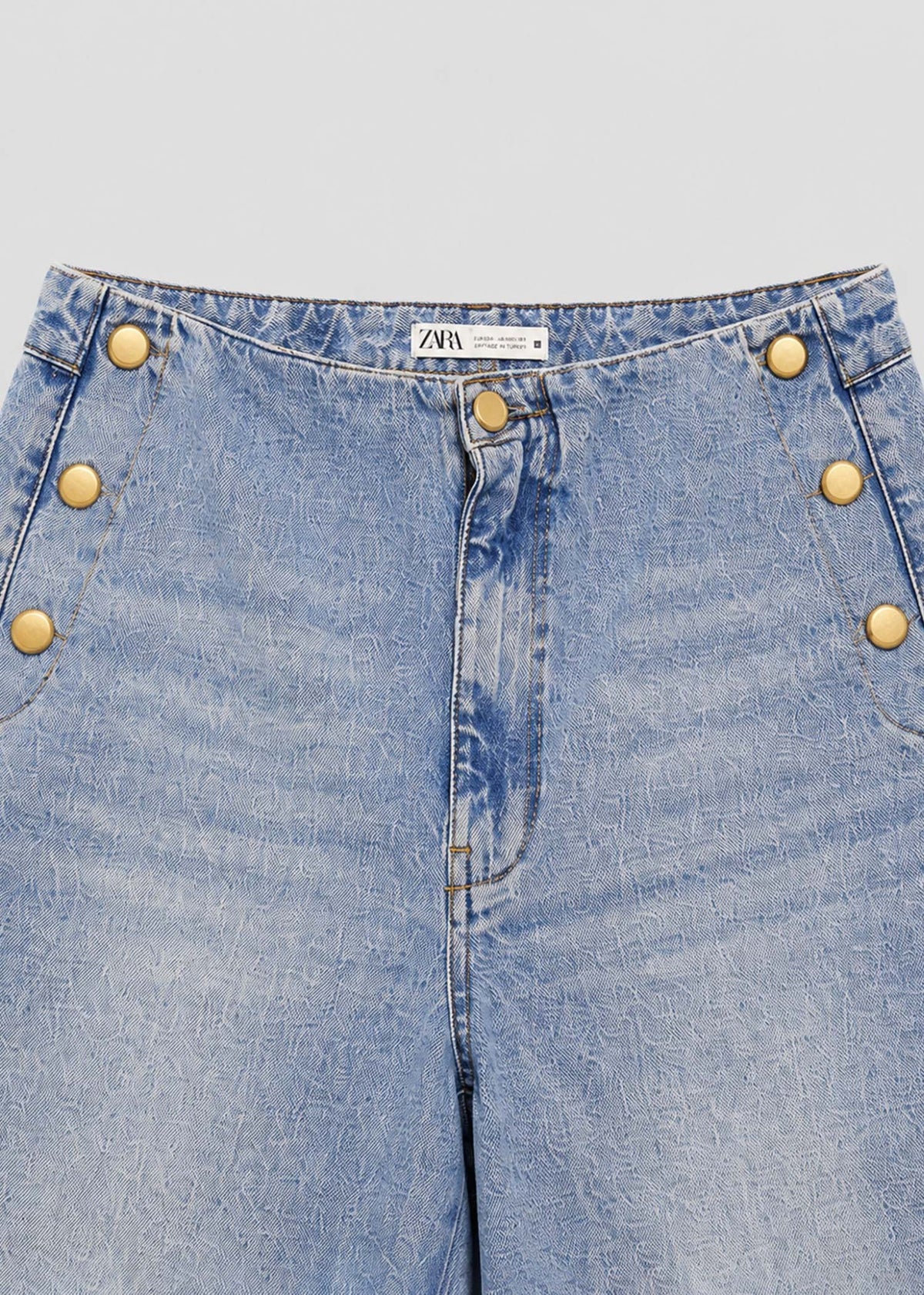 Zara light acid-wash jeans waistband and gold-button pocket detail